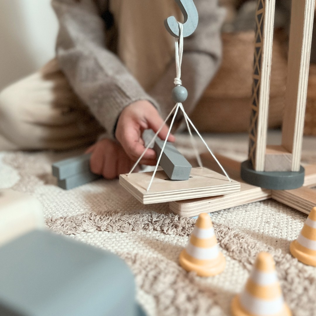 Drveno gradilište s velikim pokretnim kranom i vozilima, toranjski kran