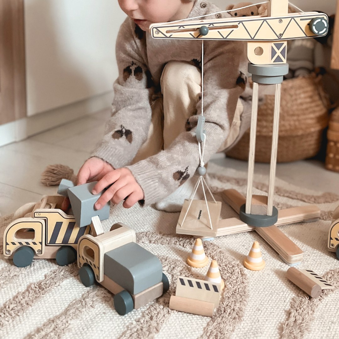 Drveno gradilište s velikim pokretnim kranom i vozilima, toranjski kran