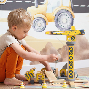 Drveno gradilište s velikim pokretnim kranom i vozilima, toranjski kran