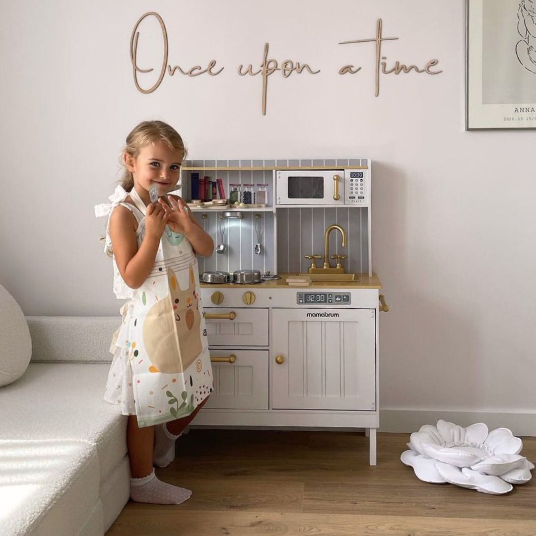 Drvena bijela kuhinja s priborom i pregačom